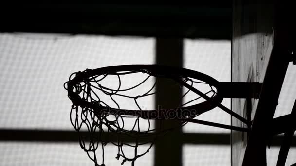 Old indoor basketball hoop in gym at school. Ball hit the ring - Πλάνα, βίντεο