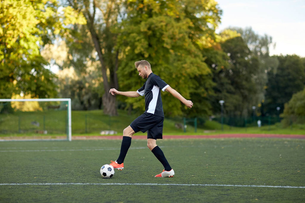 soccer player playing with ball on football field - Foto, Bild