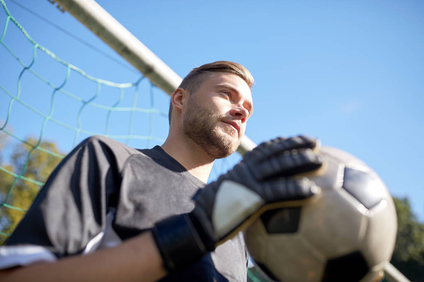 goalkeeper with ball at football goal on field - Photo, image