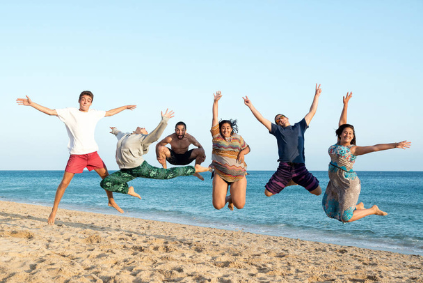 Ystävät hyppivät rannalla
 - Valokuva, kuva