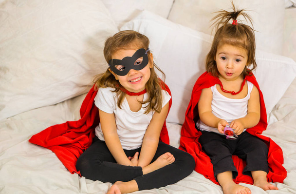 Две маленькие девочки играют в супергероев
 - Фото, изображение