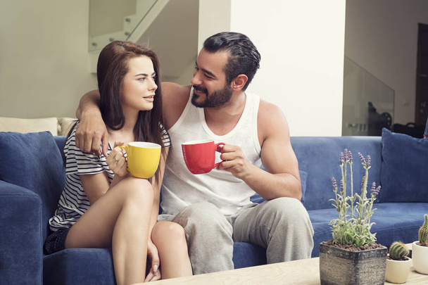 Beautiful young couple drinking coffee in the living room, Coupl - Zdjęcie, obraz