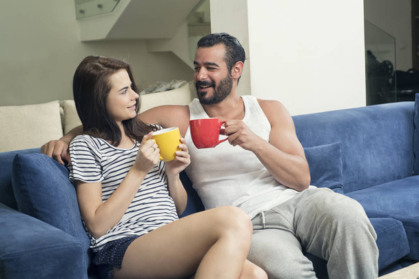 Beautiful young couple drinking coffee in the living room, Coupl - Fotó, kép