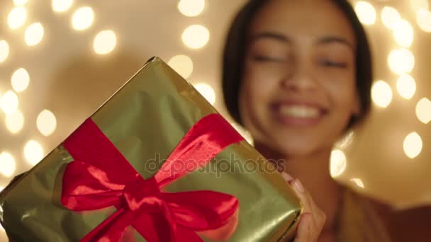Beautiful black woman keeping big gift box in her hands and smiling - Filmagem, Vídeo
