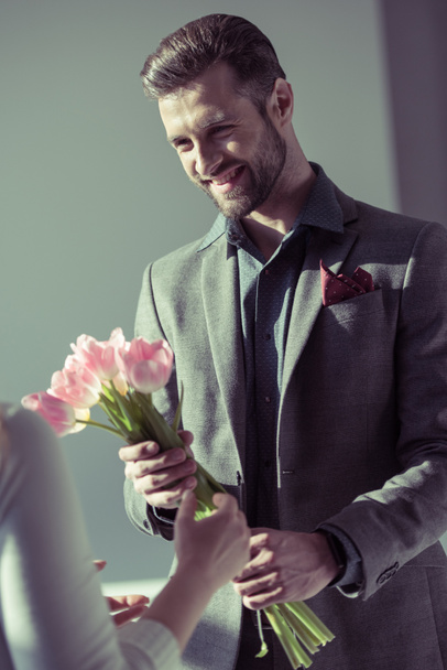 Man presenting flowers to woman - Valokuva, kuva