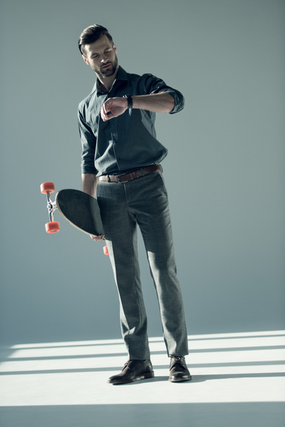 stylish man holding skateboard  - Фото, зображення