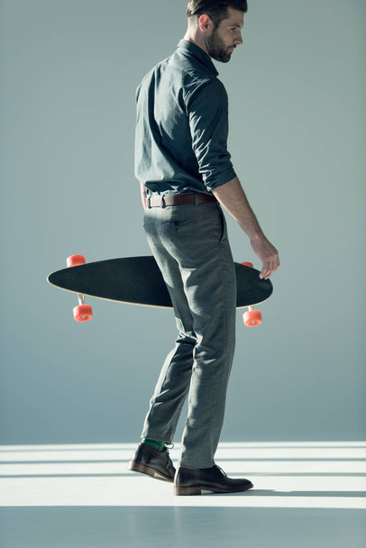 stylish man holding skateboard - Photo, Image