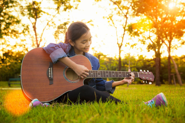 Junge Künstlerin spielt Sologitarre im grünen Naturpark - Foto, Bild