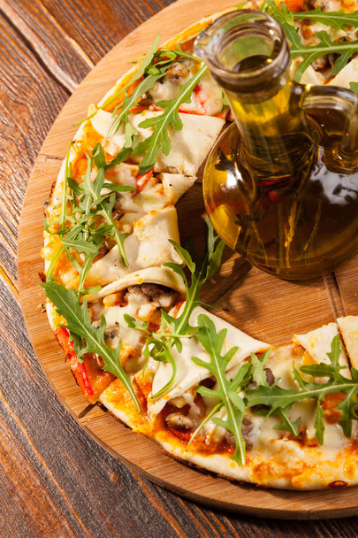 Pizza calzone with olive oil on wooden plate - Foto, Bild