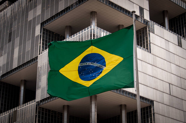 Bandera brasileña con edificio
 - Foto, Imagen