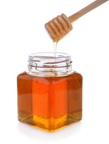 Mel com mergulhador de mel de madeira no frasco
 - Foto, Imagem