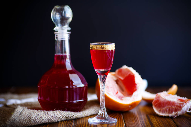sweet grapefruit alcoholic cordial in the decanter with a glass - Φωτογραφία, εικόνα