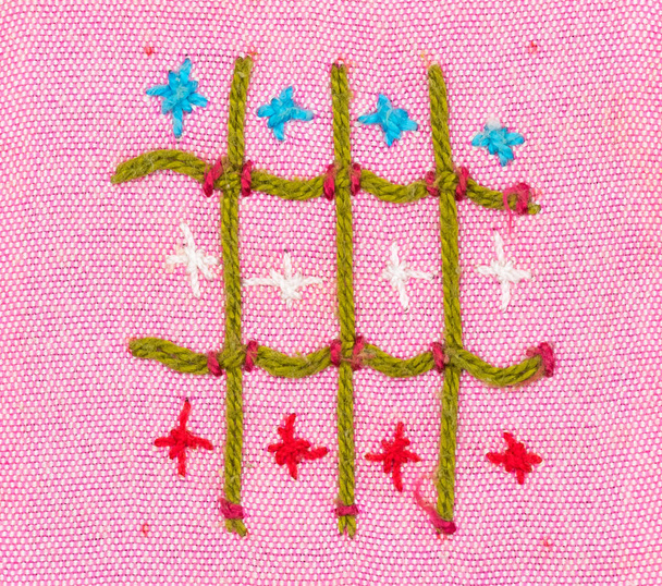 Nahaufnahme handgemachtes Stickmuster auf rosa Stoff - Foto, Bild
