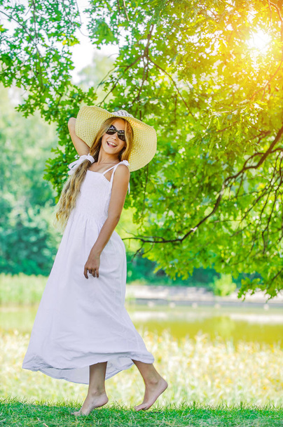 junges Mädchen in weißem Kleid, Sonnenbrille und Hut - Foto, Bild