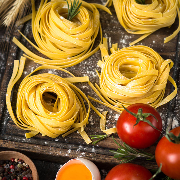 Fresh raw pasta tagliatelle and ingredients - Foto, Bild