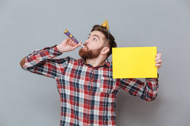 Smiling young bearded birthday man holding copyspace board - Foto, afbeelding