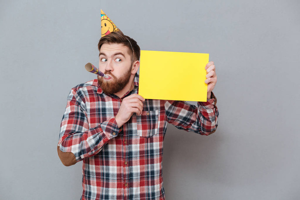 Handsome young bearded birthday man holding copyspace board - Foto, afbeelding