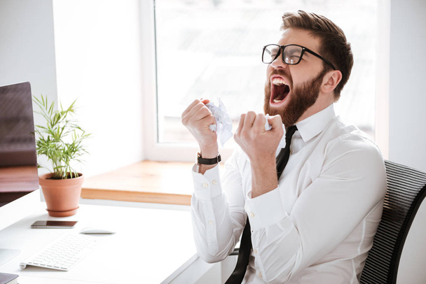Screaming angry businessman sitting in office - Fotoğraf, Görsel