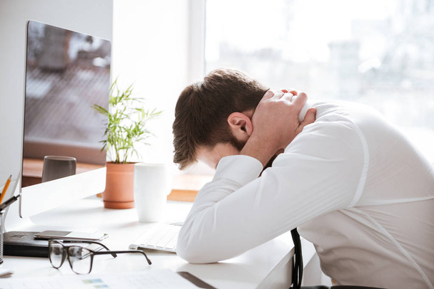 Tired young businessman with painful feelings holding neck. - Photo, Image