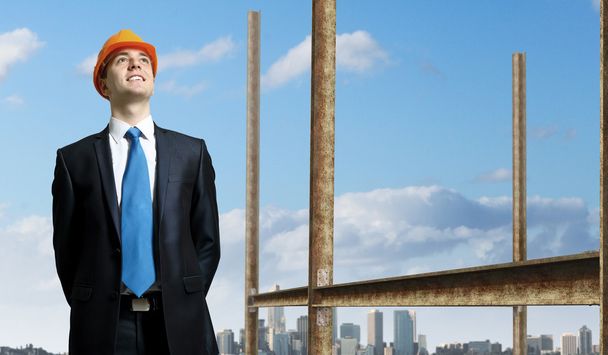 Businessman standing in suit on the construction site - Fotó, kép