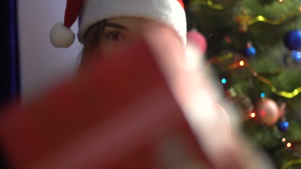 a charming young girl in Hat Santa gets Christmas gift - Filmagem, Vídeo