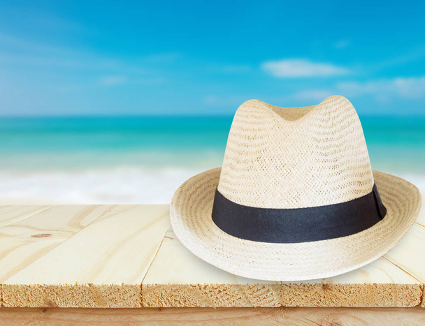 hat  over wooden table and sea landscape background - Foto, Imagem