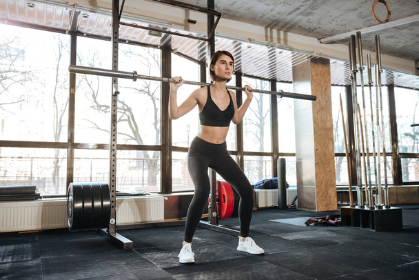 Sportswoman standing and working out in gym - Zdjęcie, obraz