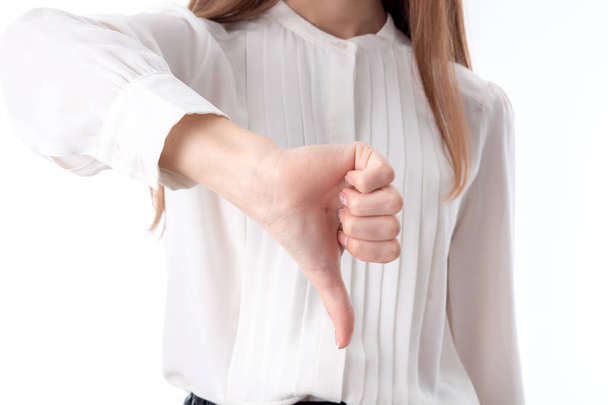 joven chica en camisa blanca muestra un gesto de mano mal primer plano
 - Foto, imagen