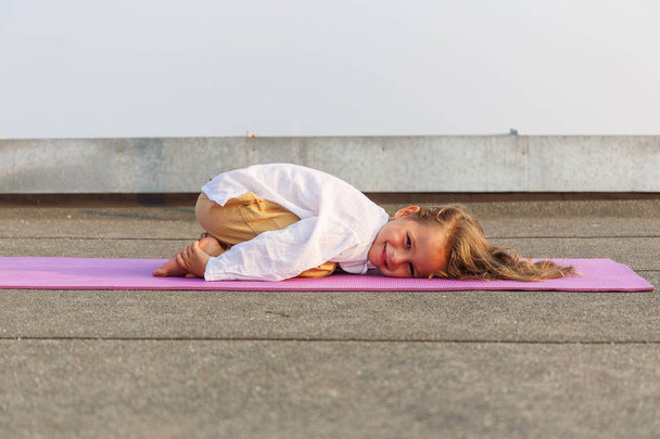 Baby doing yoga on the roof - Foto, imagen