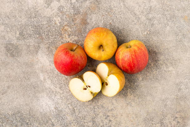 Τρεις ολόκληρες και ένα μήλο κομμένο σε φέτες - Φωτογραφία, εικόνα