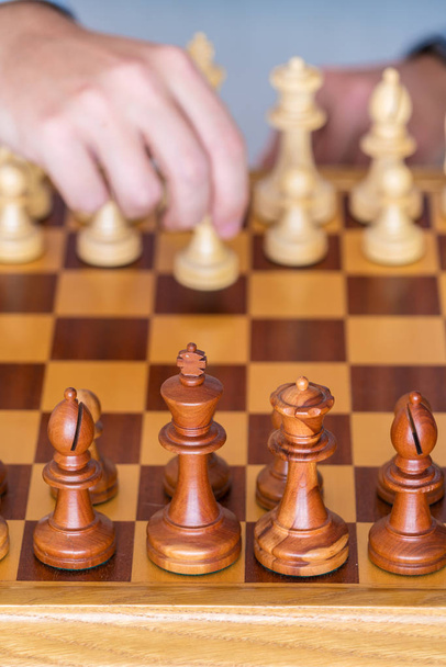 Hand with pawn makes first move on chess Board - Foto, Imagem