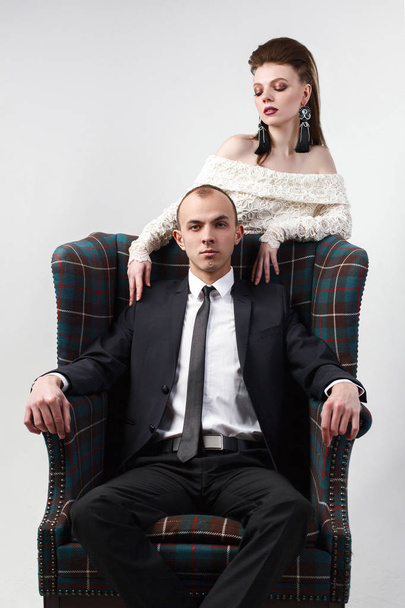 The groom is dressed in a chair with his wife - Фото, зображення