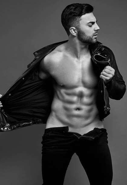Muscular brutal handsome man in leather jacket - Fotoğraf, Görsel