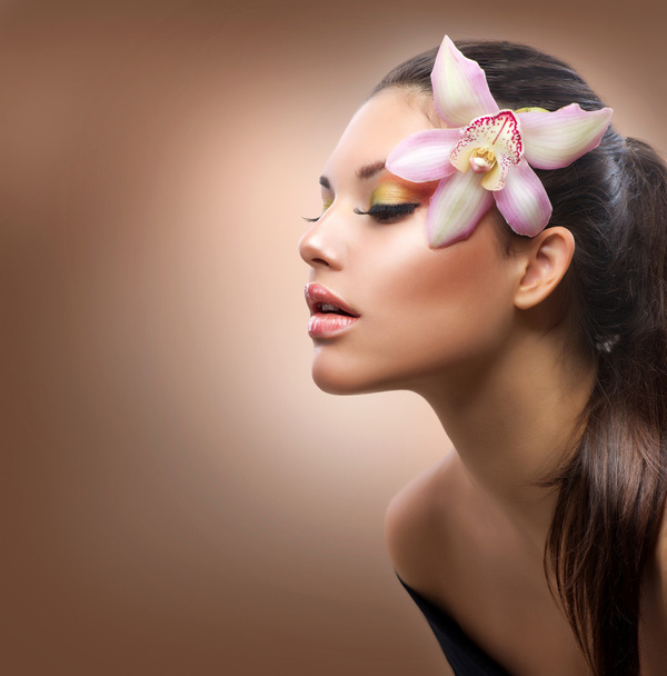 Beauty Portrait. Beautiful Stylish Girl with Orchid Flower - Foto, imagen