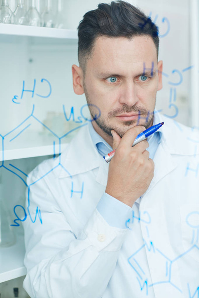 cientista que olha para fórmulas químicas
 - Foto, Imagem