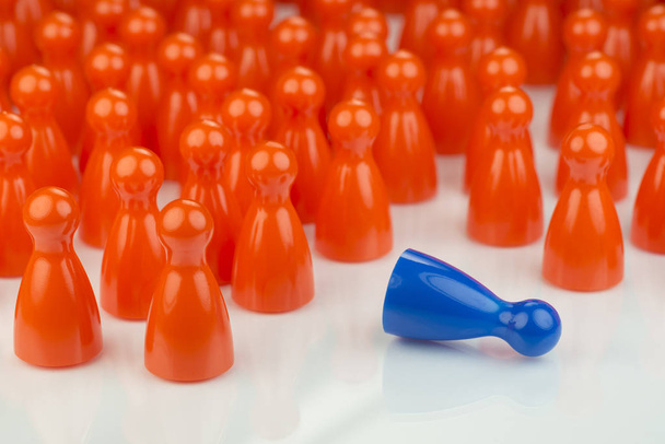 Peones de juego naranja conceptual y un peón de juego azul
 - Foto, imagen