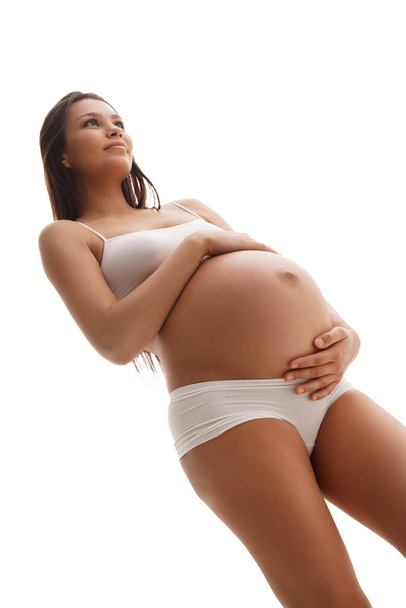 Pregnant young woman in lingerie shot from below - Fotó, kép
