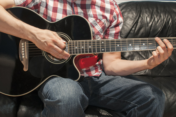 Een zwarte akoestische gitaar spelen - Foto, afbeelding