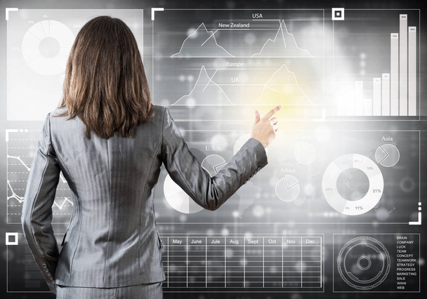 Businesswoman standing with back and pressing icon on media screen - Photo, Image