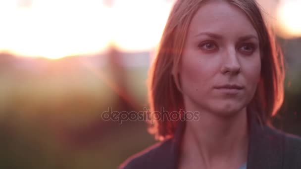 Portrait of beautiful blonde pensive woman outdoor in the summer, looking into the distance on sunset, close-up - Video