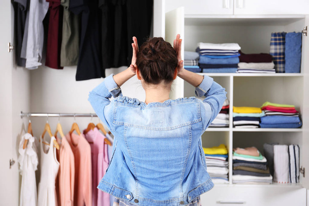 Woman choosing clothes at home - Фото, изображение