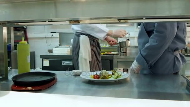 Kuchaři učí mladý praktikant, jak sloužit omáčka - Záběry, video