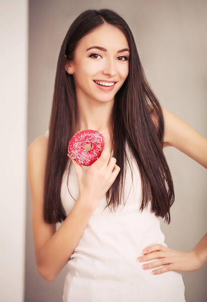 Dieet. Een jonge vrouw horloges haar figuur en vers fruit eten. Het begrip van gezond eten. - Foto, afbeelding