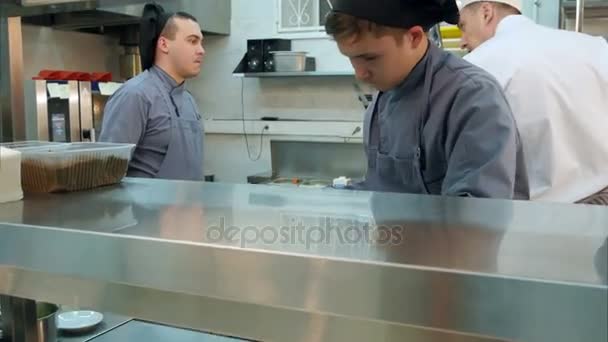 Auszubildende Köchin gießt Sauce auf leckere Garnelen mit Zitronen - Filmmaterial, Video