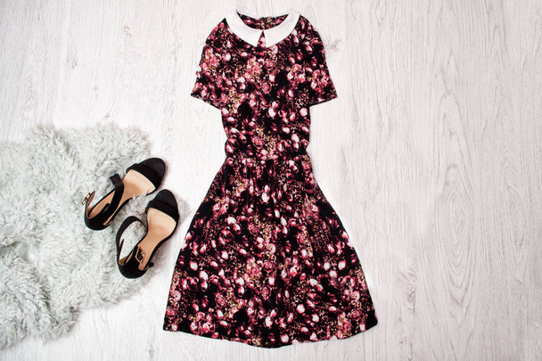 Μαύρο και ροζ φόρεμα με λαιμόκοψη, μαύρα παπούτσια γκρι γούνα, ξύλινο υπόβαθρο. Μοντέρνα ιδέα, κάτοψη, χώρο για το κείμενο - Φωτογραφία, εικόνα