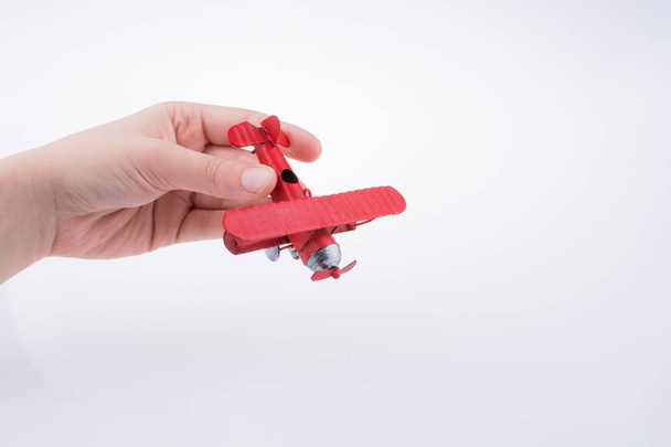 Hand holding a toy plane on a white background - Foto, Imagen