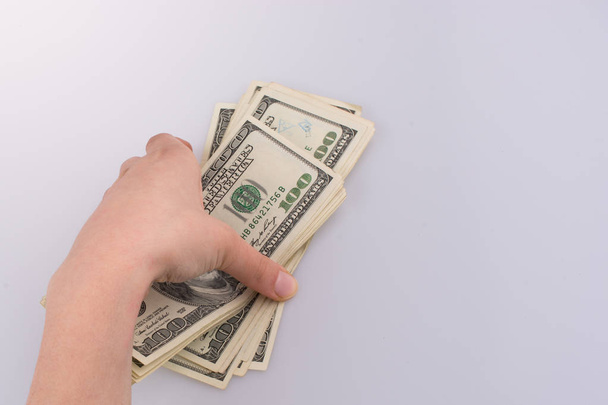 Mano humana sosteniendo billetes en dólares americanos sobre fondo blanco
 - Foto, Imagen