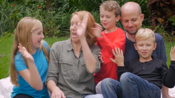 Een moeder, vader, twee broers en zus hoge vijf met elkaar - Video