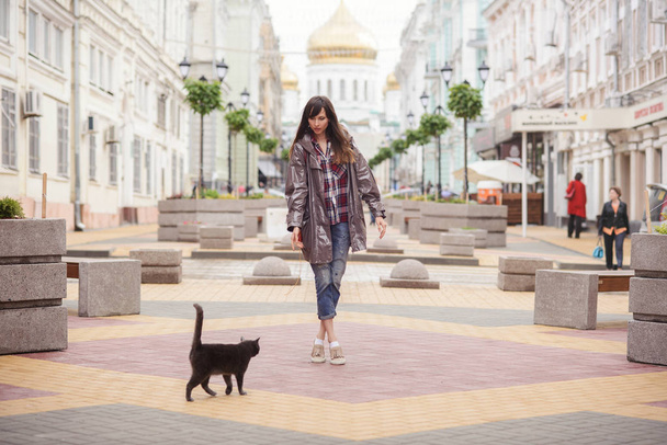 hermosa mujer caminando con un gato en la ciudad
  - Foto, imagen