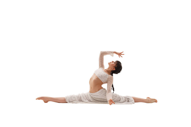 Young sexy girl in white doing splits in studio - Photo, Image